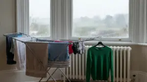 Biancheria stesa su uno stendibiancheria interno davanti a una finestra in un giorno di pioggia