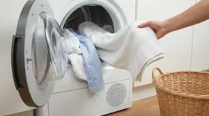 Una persona estrae panni asciutti dall'asciugatrice accanto a un cesto in vimini