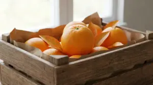 Cassetta di legno con arance fresche su carta marrone