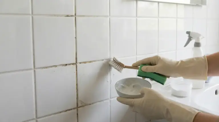 Pulizia delle piastrelle del bagno con spazzola e rimedio fai da te