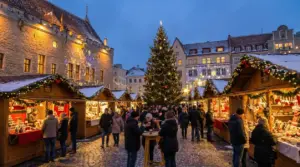 Persone che visitano un mercatino di Natale con bancarelle illuminate e un grande albero al centro