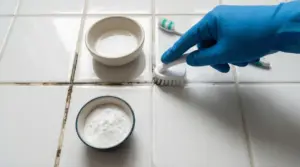 Pulizia delle fughe nere tra piastrelle con spazzolino e ingredienti naturali